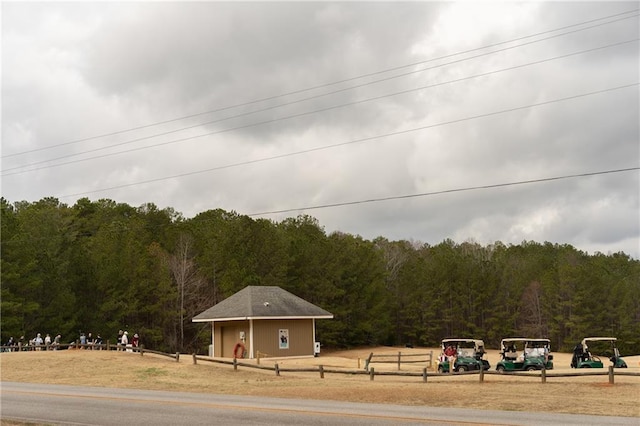 surrounding community with a wooded view and fence