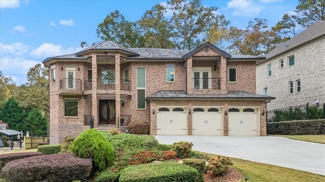 view of front of property with a balcony, driveway, a garage, and brick siding