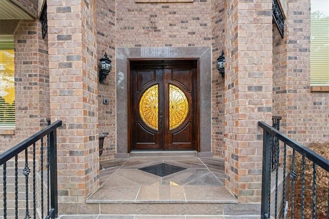 entrance to property featuring french doors and brick siding