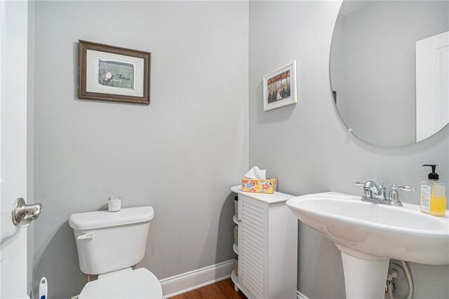 bathroom with hardwood / wood-style flooring, sink, and toilet