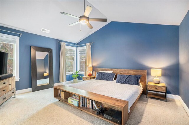 bedroom featuring light carpet, multiple windows, ceiling fan, and vaulted ceiling