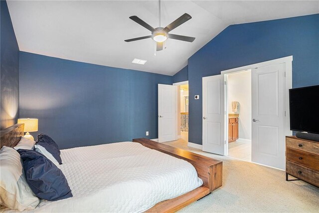 bedroom with light colored carpet, vaulted ceiling, ensuite bathroom, and ceiling fan