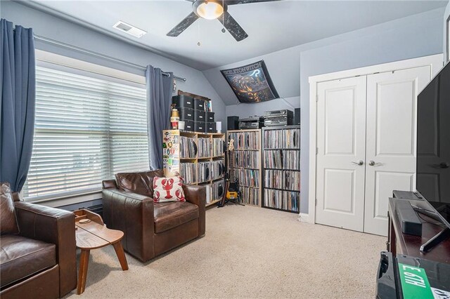 living area with light carpet, vaulted ceiling, and ceiling fan