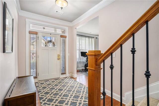 entryway with light wood-type flooring and crown molding