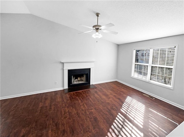 unfurnished living room featuring dark hardwood / wood-style flooring, a textured ceiling, vaulted ceiling, and ceiling fan