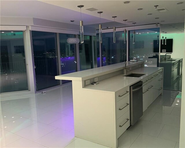 361 17th St NW Unit 2423, Atlanta, GA 30363 - kitchen with modern cabinets, a sink, a large island with sink, light tile patterned floors, and decorative light fixtures