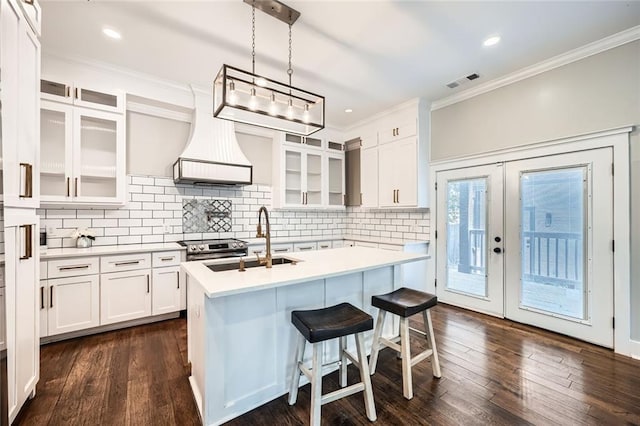 kitchen with white cabinets, a center island with sink, sink, dark hardwood / wood-style flooring, and custom range hood