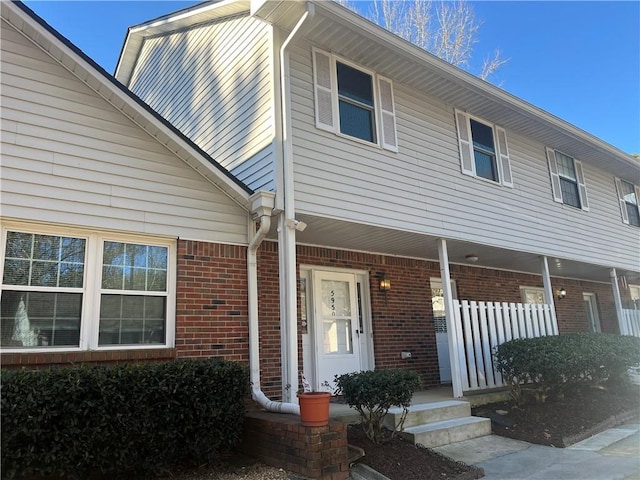 view of front of house featuring covered porch and brick siding