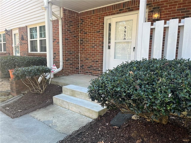 doorway to property featuring brick siding