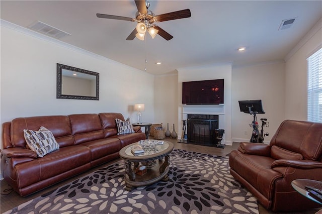 living room featuring ceiling fan, a high end fireplace, ornamental molding, and hardwood / wood-style flooring