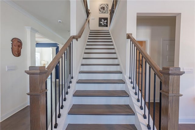 stairs featuring wood-type flooring and crown molding