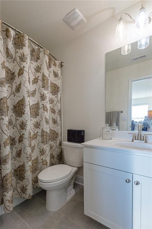 bathroom featuring toilet, tile patterned floors, and vanity