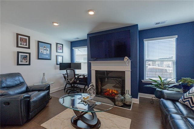 living room featuring dark wood-type flooring and plenty of natural light