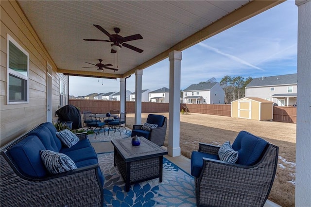 view of patio with an outdoor living space, ceiling fan, and a shed