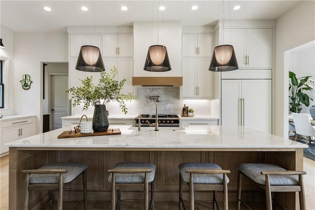 320 Shady Grove Ln, Alpharetta, GA 30009 - kitchen featuring paneled fridge, tasteful backsplash, white cabinets, a spacious island, and light stone countertops