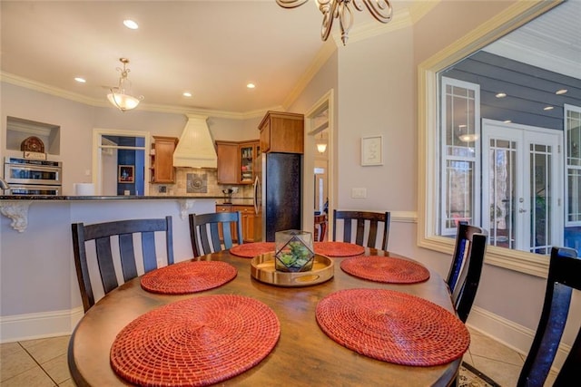 dining space featuring french doors, ornamental molding, recessed lighting, light tile patterned floors, and a chandelier