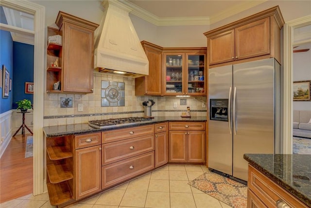 kitchen with open shelves, appliances with stainless steel finishes, custom exhaust hood, brown cabinets, and ornamental molding