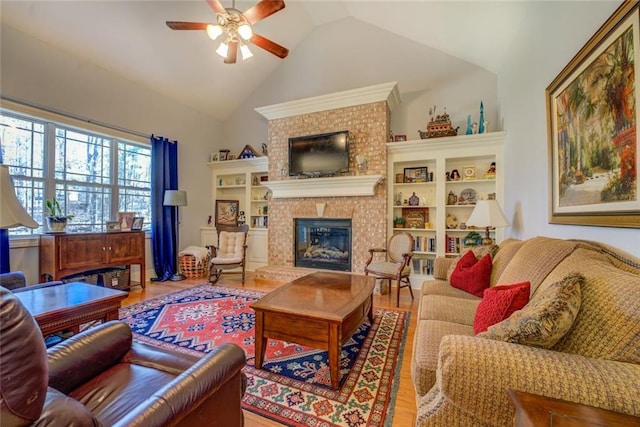 living area with a fireplace, ceiling fan, lofted ceiling, and wood finished floors