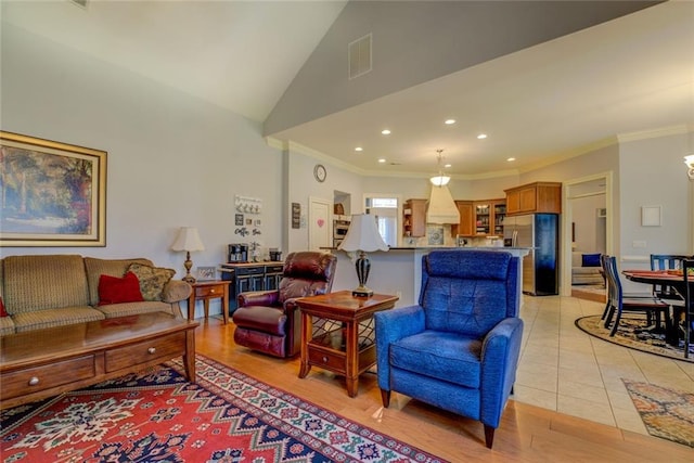 living room with crown molding, lofted ceiling, recessed lighting, and light wood finished floors