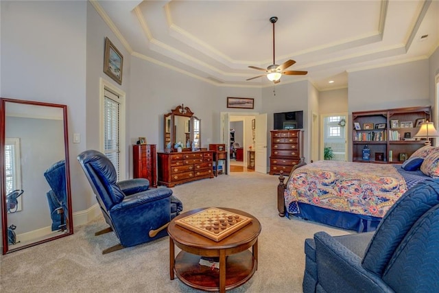 bedroom featuring ornamental molding, carpet, a tray ceiling, and ceiling fan