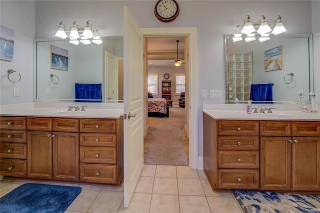 ensuite bathroom with a chandelier, tile patterned floors, and two vanities