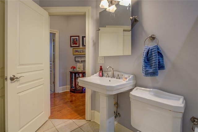 bathroom with tile patterned flooring, toilet, and baseboards