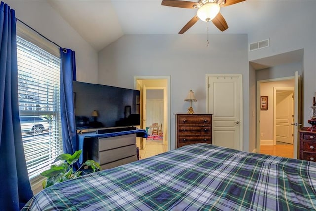 bedroom featuring lofted ceiling, a ceiling fan, and ensuite bath