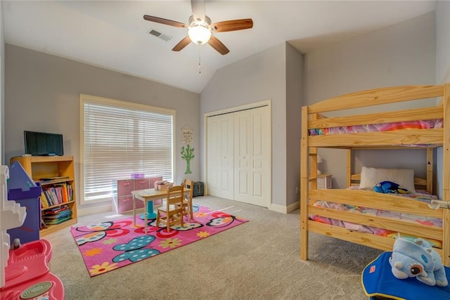 carpeted bedroom featuring a closet, lofted ceiling, and a ceiling fan