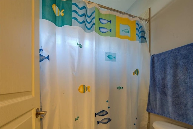 bathroom with toilet and curtained shower