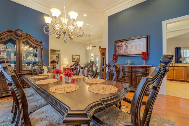 dining room with a chandelier, ornamental molding, and light wood-style floors
