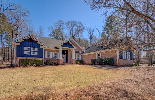 craftsman house featuring board and batten siding, a front lawn, and brick siding