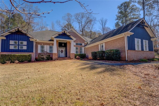 view of front facade featuring board and batten siding, brick siding, and a front lawn