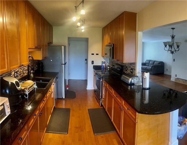 750 Dalrymple Rd Unit G3, Atlanta, GA 30328 - kitchen with appliances with stainless steel finishes, a sink, brown cabinets, and backsplash