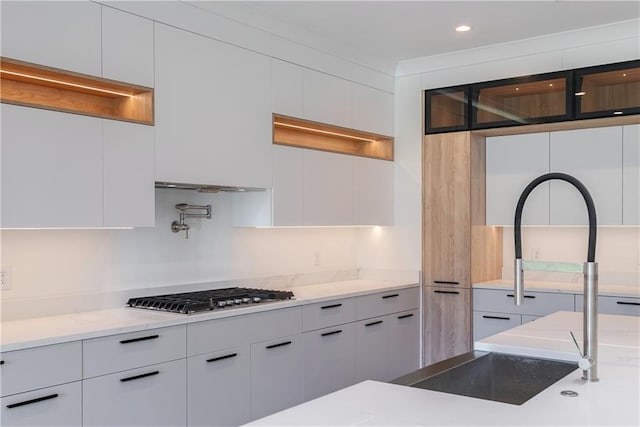 kitchen with white cabinetry, stainless steel gas cooktop, and sink