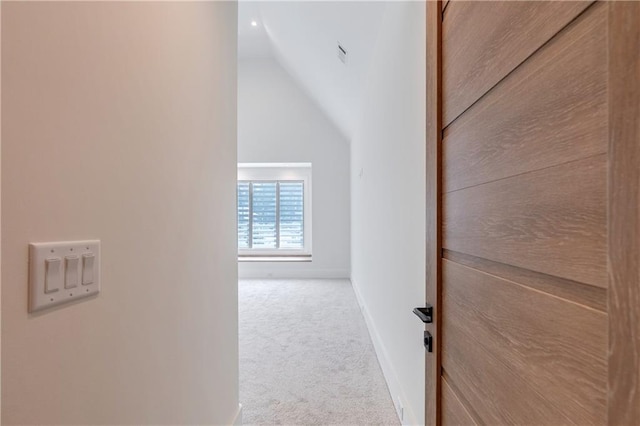 hall with carpet flooring and lofted ceiling