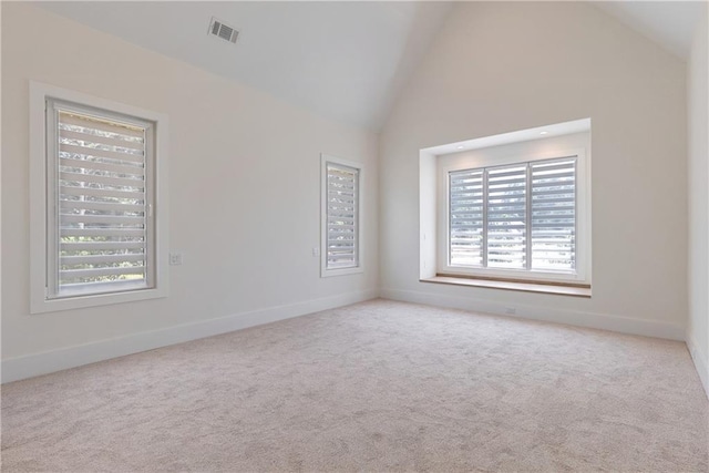 carpeted spare room featuring high vaulted ceiling