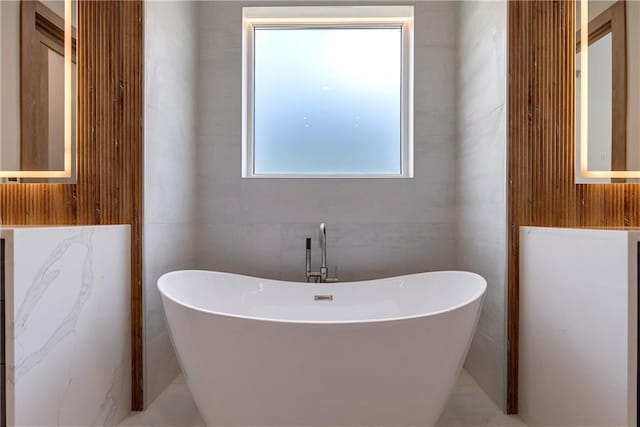 bathroom featuring a tub and tile walls