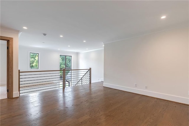 spare room featuring ornamental molding and dark wood-type flooring