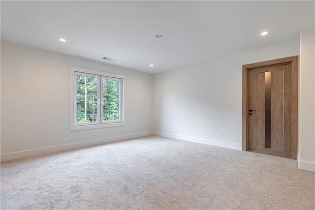 spare room featuring light colored carpet