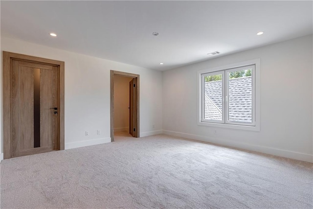 spare room featuring light colored carpet