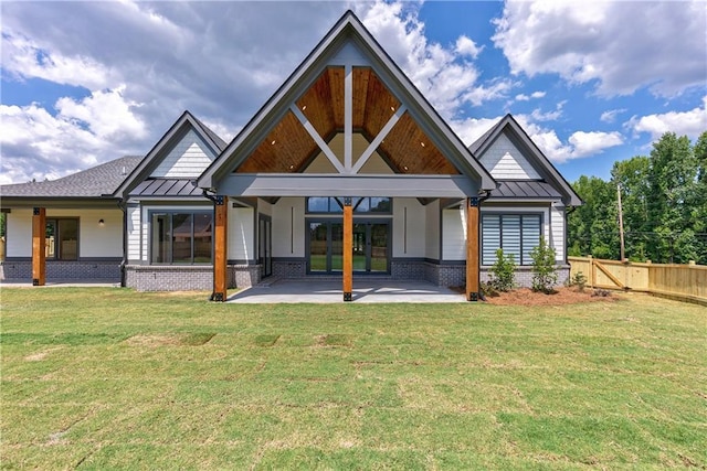 back of property featuring a patio area and a yard