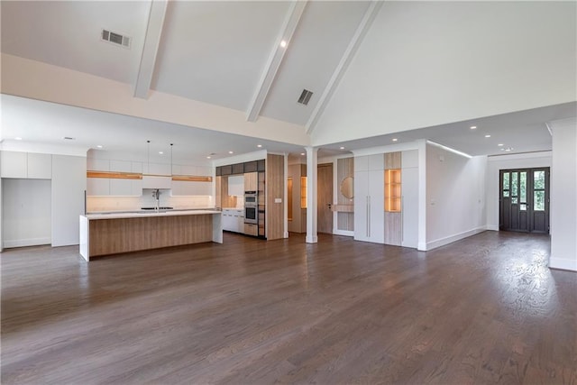 unfurnished living room with beamed ceiling, dark hardwood / wood-style floors, sink, and high vaulted ceiling