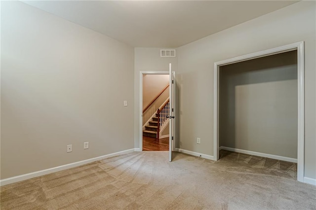 unfurnished bedroom featuring light carpet