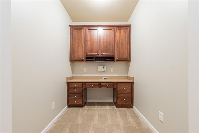 unfurnished office featuring light colored carpet and lofted ceiling