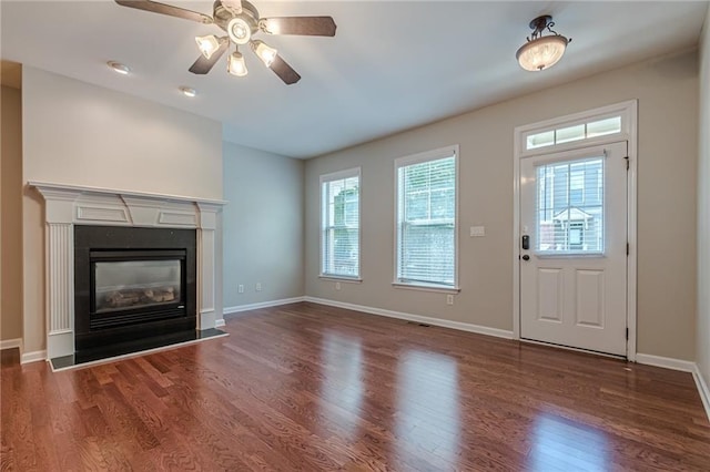 unfurnished living room with ceiling fan and dark wood-type flooring