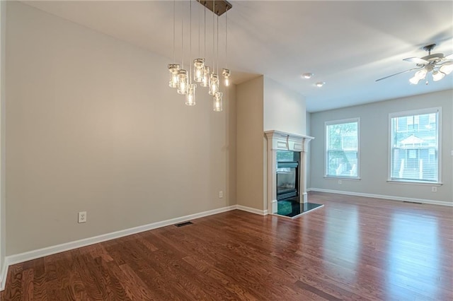 unfurnished living room with a fireplace, wood-type flooring, and ceiling fan