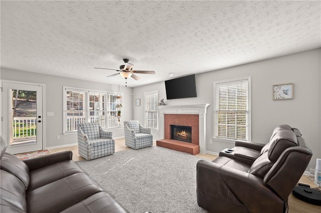 carpeted living room with a textured ceiling and ceiling fan