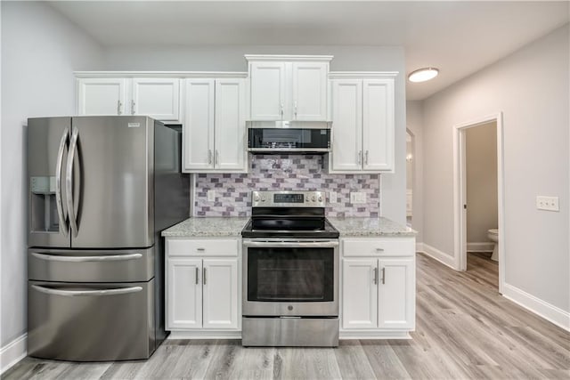 kitchen featuring light stone counters, light hardwood / wood-style flooring, decorative backsplash, white cabinets, and appliances with stainless steel finishes