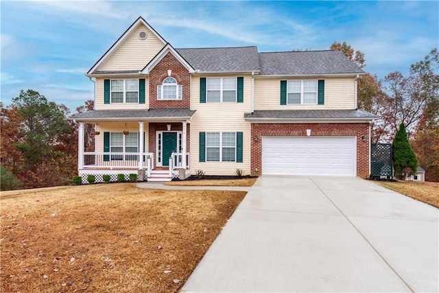 view of front of home with covered porch, a garage, and a front lawn