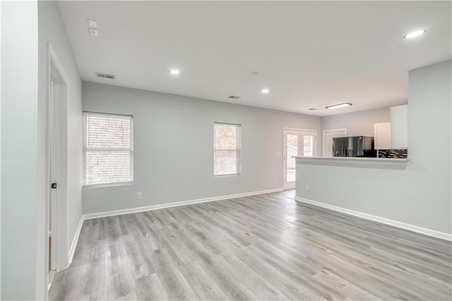 unfurnished living room with french doors and light hardwood / wood-style flooring